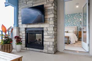 Raised deck off of the primary suite with a stone fireplace