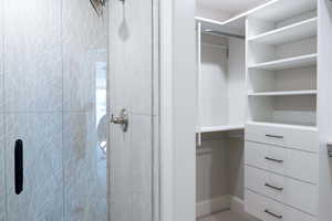 Bathroom featuring a shower and walk-in closet