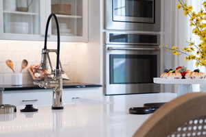 Kitchen with stainless steel appliances and decorative backsplash