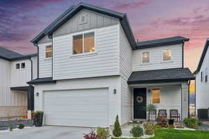 View of front of house with central AC and a garage