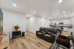 Living room with sink and light hardwood / wood-style flooring