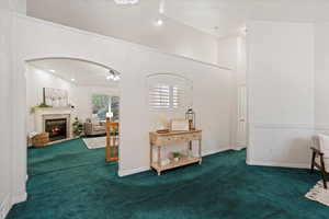 Interior space with dark colored carpet and ceiling fan