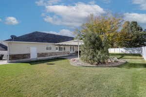 Back of property featuring a yard and a patio area