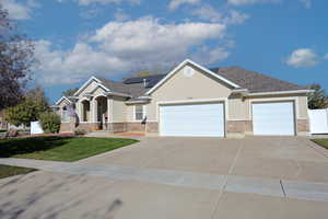 View of front of property featuring a front lawn and a garage