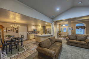 Living room featuring high vaulted ceiling and an inviting chandelier