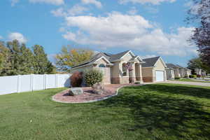 View of front of property with a front yard and a garage