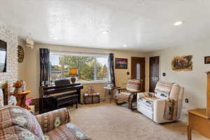 Carpeted living room with a textured ceiling and a brick fireplace