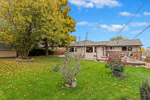 Rear view of house featuring a patio and a lawn