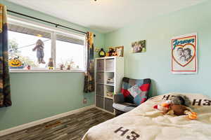 Bedroom with dark hardwood / wood-style flooring