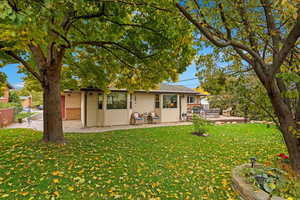 Back of property featuring a yard and a patio area.  Easy access around the house on paved walkway.