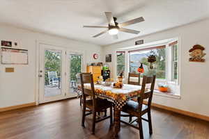 Dining area featuring a textured ceiling, a healthy amount of sunlight, and dark hardwood / wood-style flooring