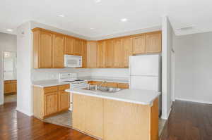 Kitchen with a center island with sink, sink, light hardwood / wood-style flooring, and white appliances