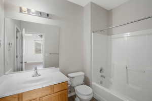 Full bathroom with vanity, toilet, shower / tub combination, and ceiling fan