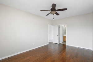 Unfurnished room with dark hardwood / wood-style floors and ceiling fan