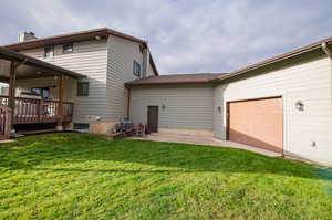 Rear view of property with a Trex deck and access to garage