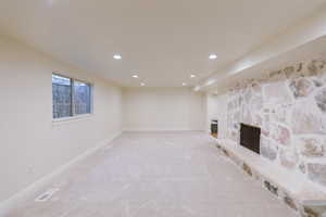 Basement featuring carpet and a stone fireplace