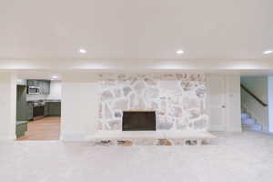 Interior details with carpet, a fireplace, and stainless steel appliances