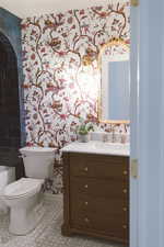 Bathroom featuring a tub to relax in, vanity, and toilet