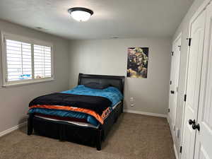 Carpeted bedroom with a textured ceiling