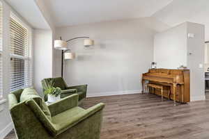 Living area with hardwood / wood-style floors and vaulted ceiling