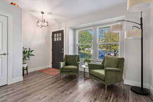 Living area featuring a chandelier and wood-type flooring