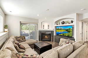 Living room with built in features and hardwood / wood-style floors