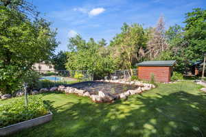 View of yard featuring a shed and a swimming pool