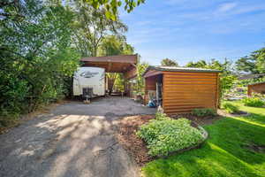 View of front of property featuring a carport and a front yard