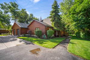 View of front of home with a front yard, a garage, and a wooden deck