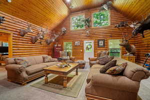 Living room with wood ceiling, high vaulted ceiling, and plenty of natural light