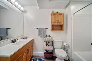 Full bathroom featuring a textured ceiling, toilet, shower / bath combination, vanity, and hardwood / wood-style flooring