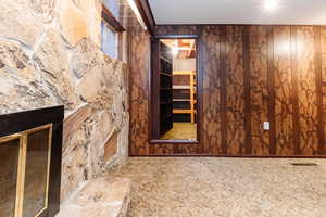 Unfurnished living room featuring carpet flooring and wood walls