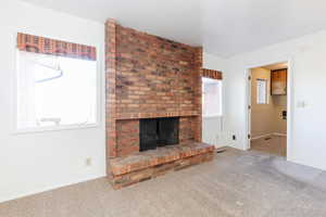 Unfurnished living room featuring a fireplace and carpet