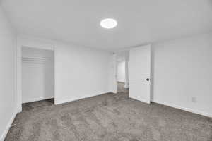 Unfurnished bedroom with dark colored carpet and a closet