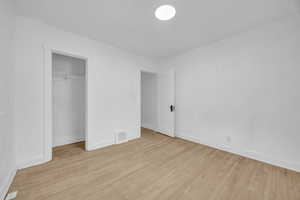 Unfurnished bedroom featuring a closet and light wood-type flooring