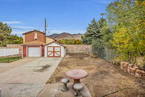 View of yard with a storage shed, a mountain view, and a garage