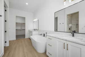 Bathroom featuring vanity, hardwood / wood-style floors, and shower with separate bathtub