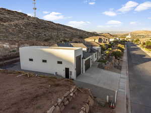 View of side of home with a mountain view and a garage