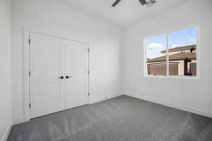 Unfurnished bedroom featuring carpet, a closet, and ceiling fan