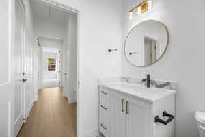 Bathroom featuring vanity, toilet, and hardwood / wood-style flooring