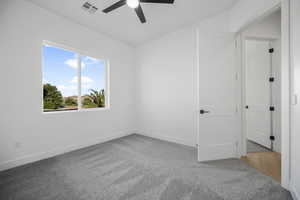 Empty room with ceiling fan and carpet flooring