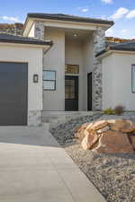 View of exterior entry with a garage