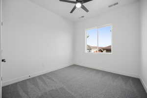 Spare room featuring carpet and ceiling fan