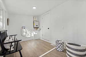 Living area featuring water heater and hardwood / wood-style floors