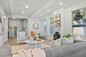 Living room featuring wood ceiling, beamed ceiling, light hardwood / wood-style flooring, a wood stove, and sink