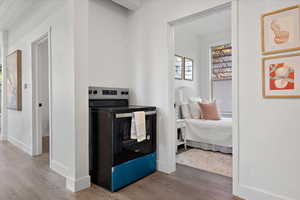 Kitchen with hardwood / wood-style flooring and stainless steel range with electric cooktop