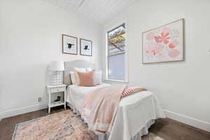 Bedroom featuring dark wood-type flooring and wood ceiling