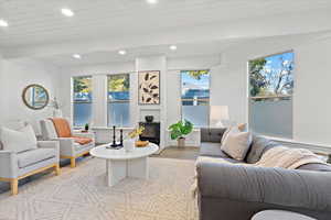 Living room with wood ceiling, beam ceiling, a wealth of natural light, and light wood-type flooring