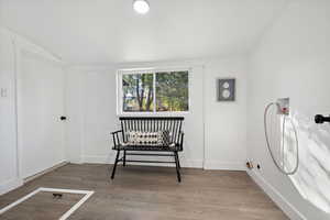 Sitting room with hardwood / wood-style flooring and vaulted ceiling