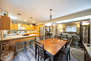 Dining space featuring sink, dark hardwood / wood-style flooring, and a notable chandelier